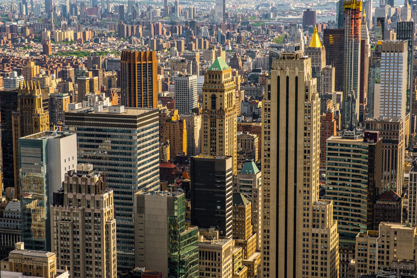 An aerial view of the Manhattan skyline in warm daylight