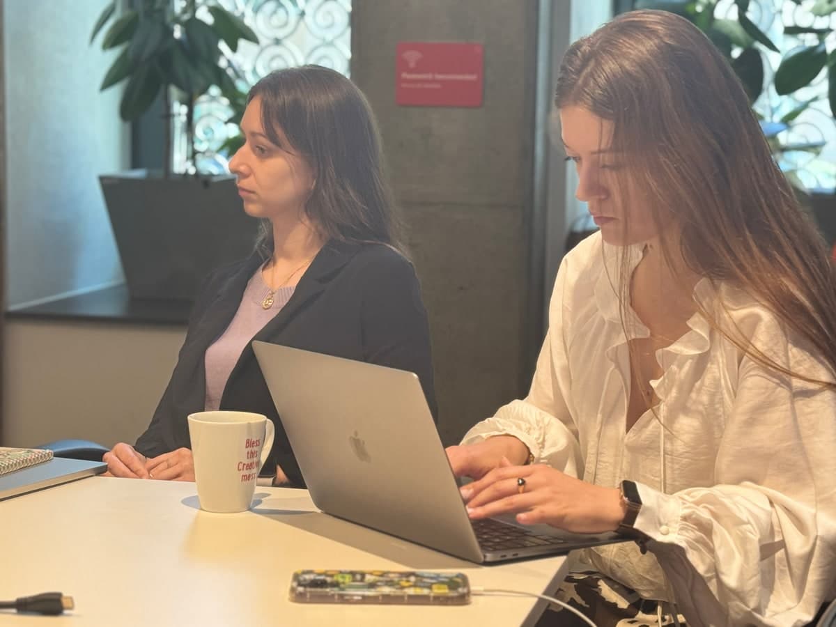 Two people planning a case together at a table, with a laptop and notes